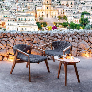 Ethimo's Knit collection lounge armchairs with a side table outside.